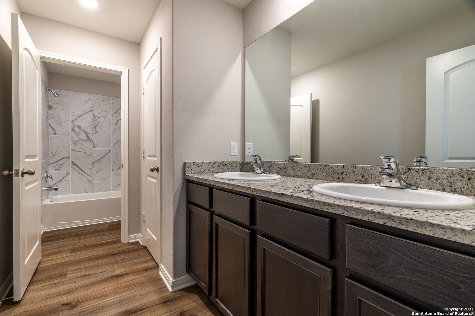 9338 Espadrille Run Converse, TX 78109 - Photo 32 of 46 a bathroom with a granite countertop sink and a mirror