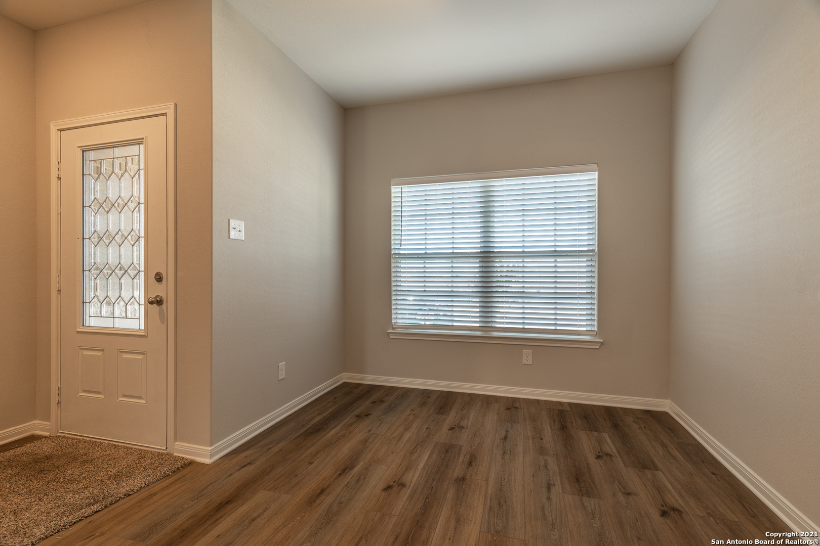 9338 Espadrille Run Converse, TX 78109 - Photo 9 of 46 a view of an empty room with wooden floor and a window