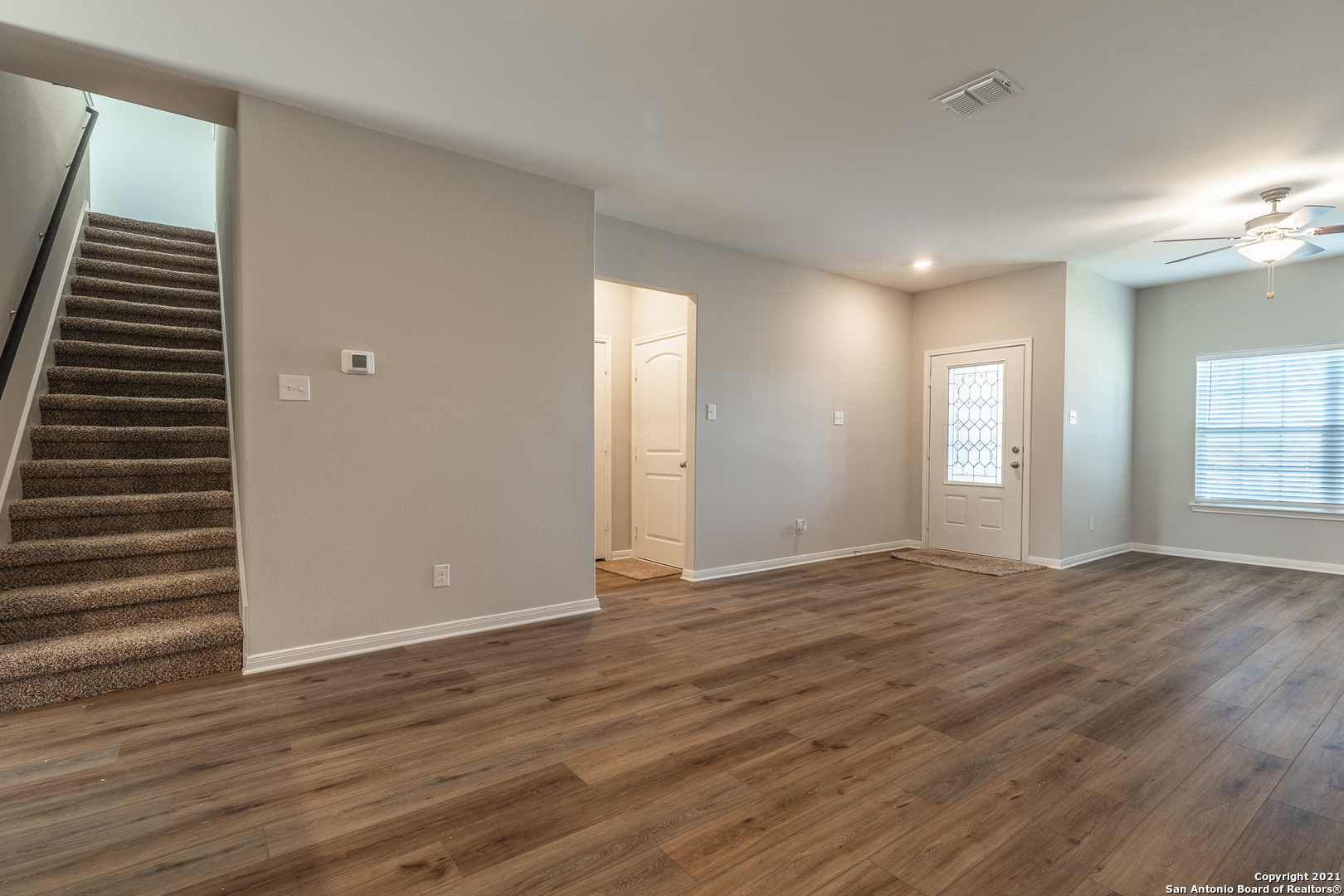 9338 Espadrille Run Converse, TX 78109 - Photo 10 of 46 a view of an empty room with wooden floor and a window
