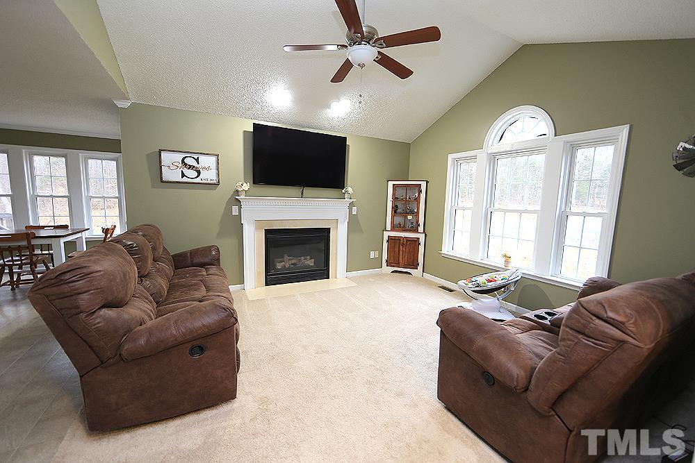 657 Thunder Road Rougemont, NC 27572 - Photo 2 of 29 a living room with furniture a fireplace and a flat screen tv