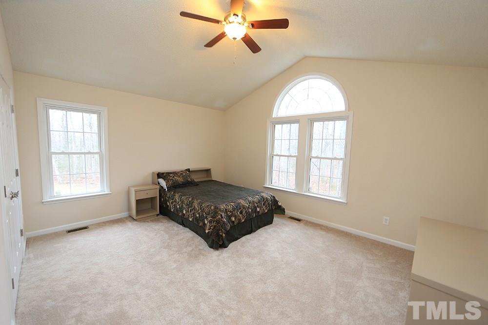 657 Thunder Road Rougemont, NC 27572 - Photo 17 of 29 a spacious bedroom with a bed and a chandelier
