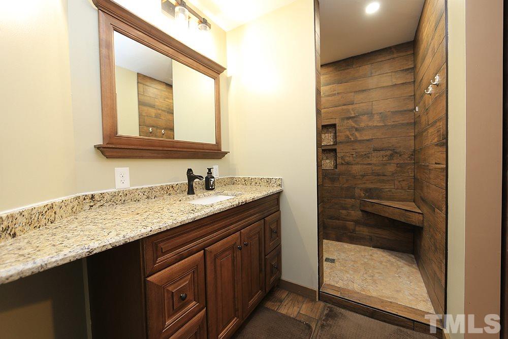 657 Thunder Road Rougemont, NC 27572 - Photo 22 of 29 a bathroom with a granite countertop sink and mirror