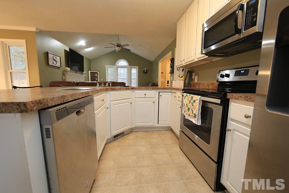 657 Thunder Road Rougemont, NC 27572 - Photo 9 of 29 a kitchen with stainless steel appliances granite countertop a sink a stove and a refrigerator