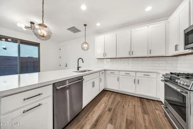 a kitchen with stainless steel appliances a refrigerator and a stove top oven