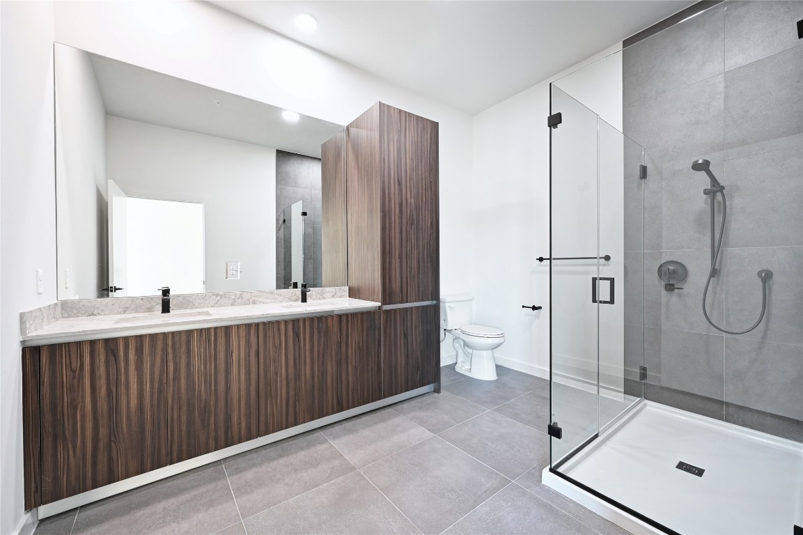 2209 South 1st Street, Unit 118 Austin, TX 78704 - Photo 12 of 36 a bathroom with a double vanity sink mirror and shower