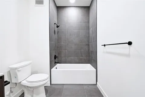 a white toilet sitting next to a white tub