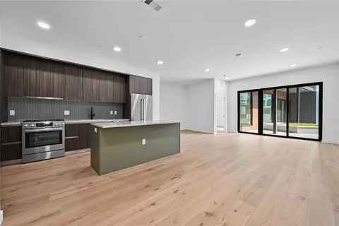 a kitchen with a refrigerator and a stove top oven