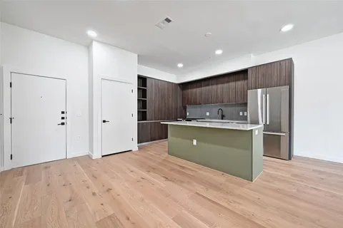 a kitchen with kitchen island a refrigerator sink and cabinets