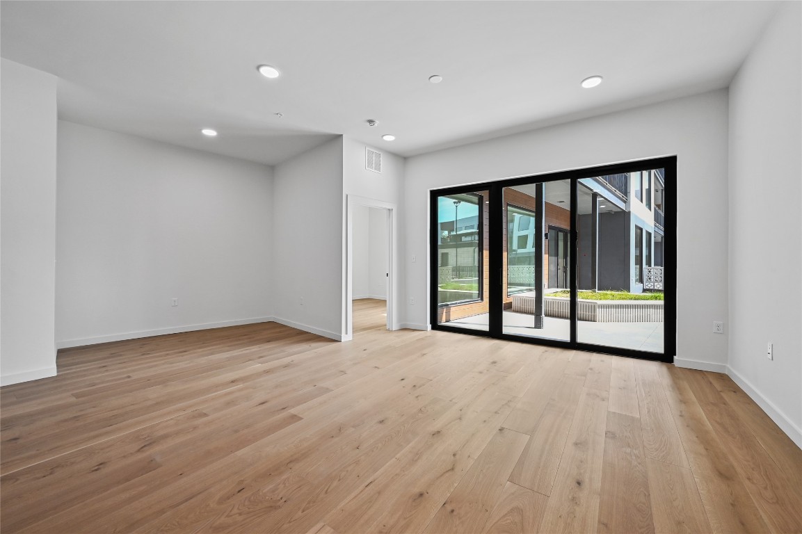 2209 South 1st Street, Unit 118 Austin, TX 78704 - Photo 7 of 36 a view of an empty room with wooden floor and a window