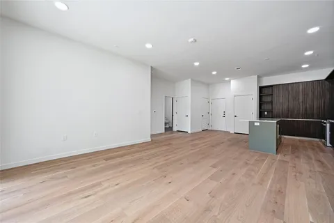 a view of a kitchen with a refrigerator and a wooden floor