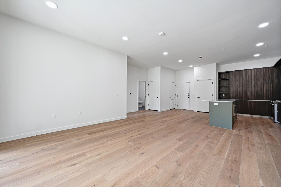 2209 South 1st Street, Unit 118 Austin, TX 78704 - Photo 10 of 36 a view of a kitchen with a refrigerator and a wooden floor