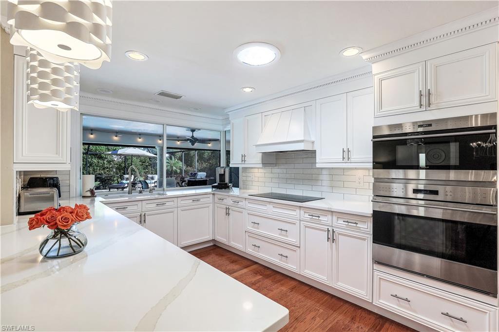 635 Anchor Rode Drive Naples, FL 34103 - Photo 13 of 50 a kitchen with white cabinets and white appliances