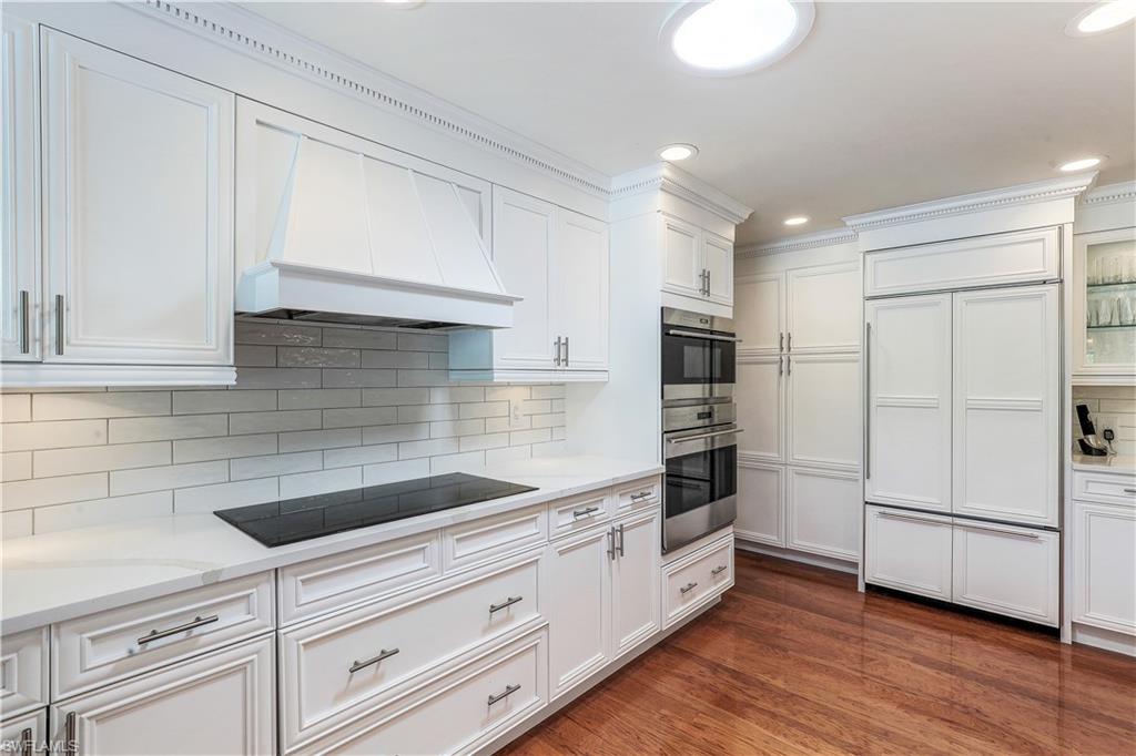 635 Anchor Rode Drive Naples, FL 34103 - Photo 16 of 50 a kitchen with granite countertop white cabinets and stainless steel appliances