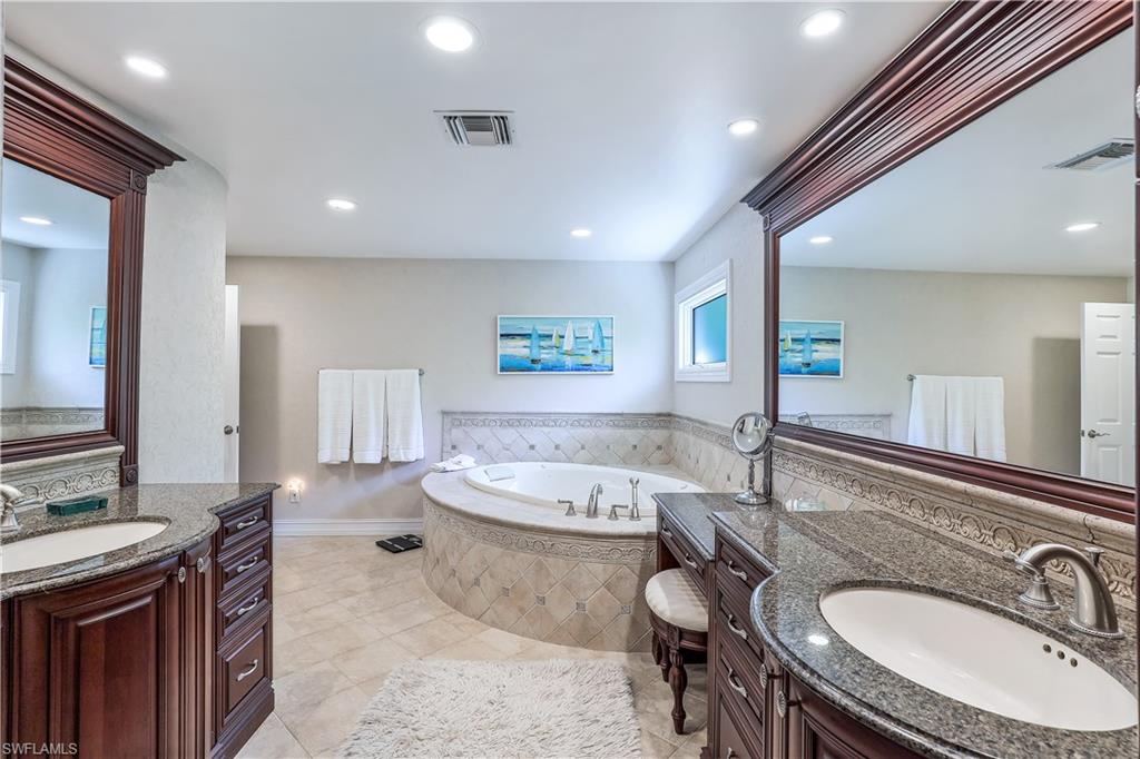 635 Anchor Rode Drive Naples, FL 34103 - Photo 24 of 50 a bathroom with a granite countertop sink and a mirror