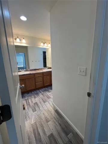 a view of a room with baby crib and wooden floor