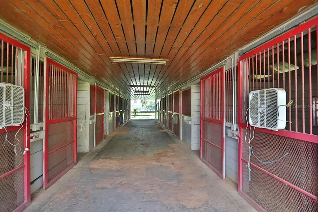 an aerial view of a houses with outdoor space and trees all around
