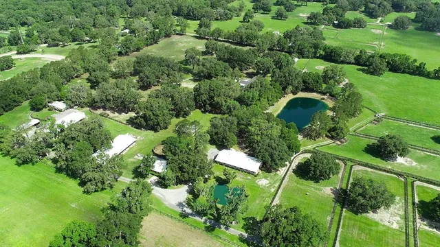 a dining room with wooden floor a chandelier a wooden table and chairs