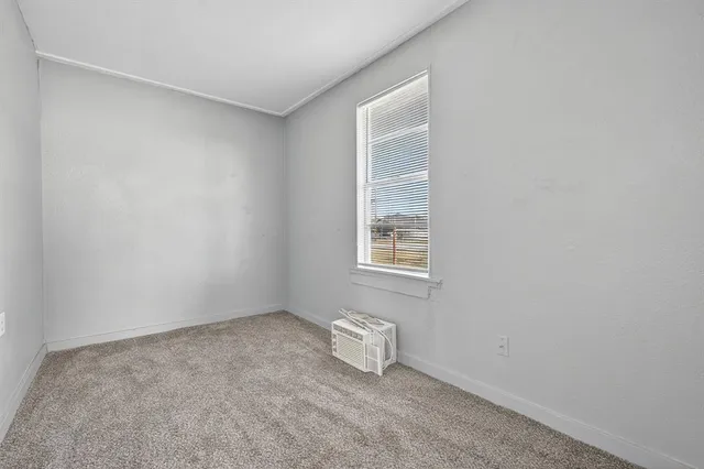 a view of a small space with wooden floor and a window