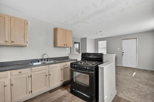 a kitchen with stainless steel appliances granite countertop a stove a sink and white cabinets