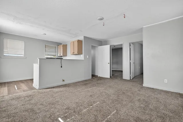 a view of empty room with window and refrigerator