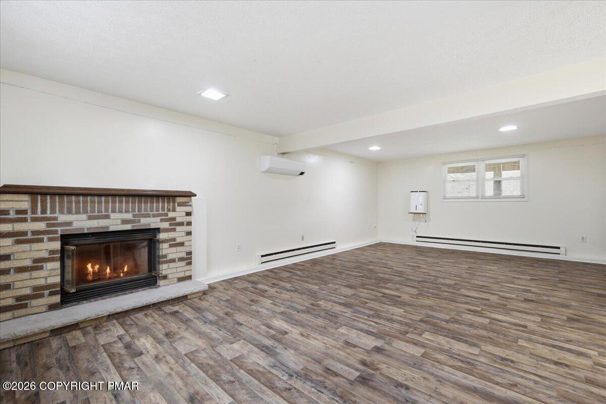 606 Rimrock Road Bartonsville, PA 18321 - Photo 12 of 36 a view of an empty room with wooden floor fireplace and a window