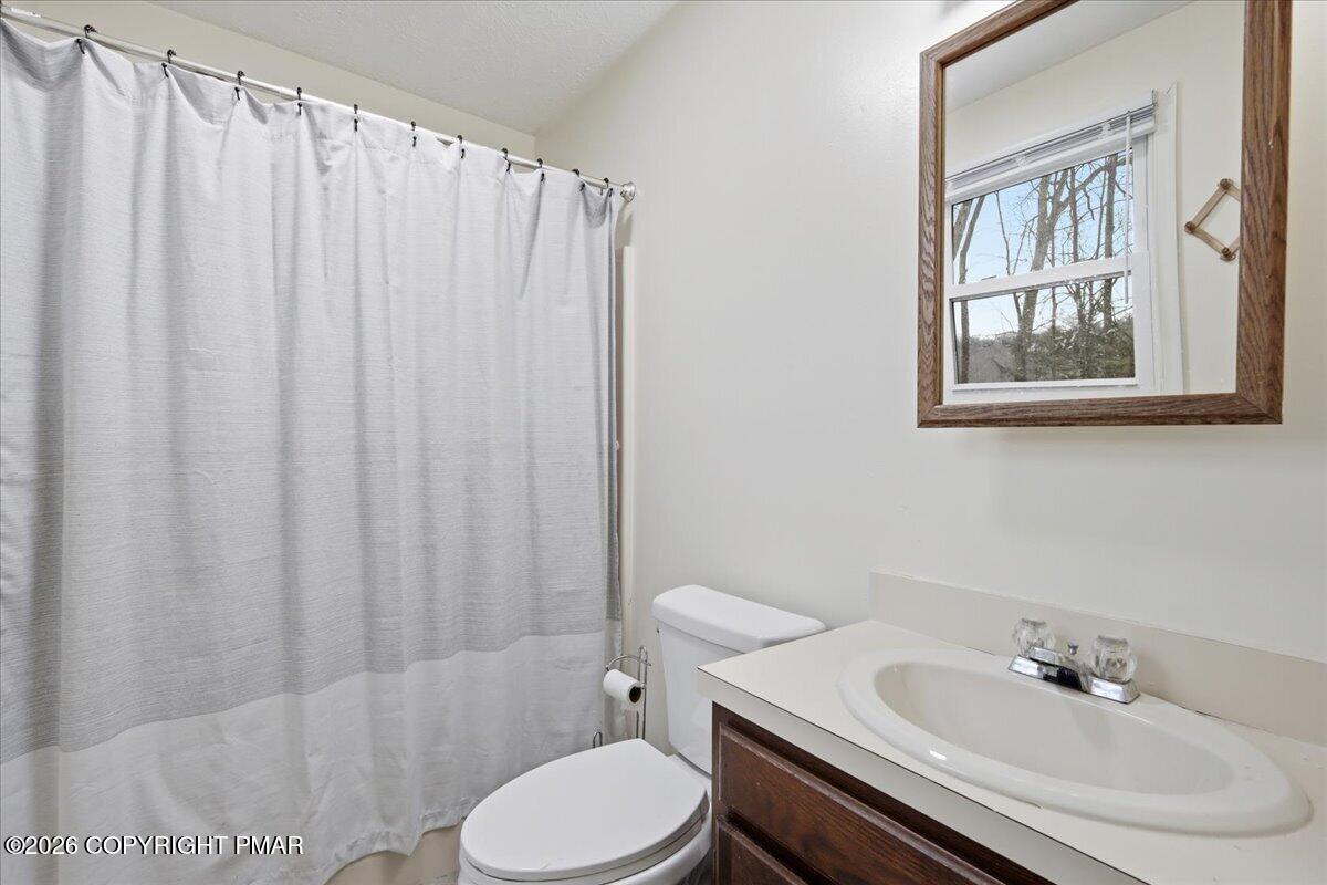 606 Rimrock Road Bartonsville, PA 18321 - Photo 15 of 36 a bathroom with a sink a toilet and shower curtain