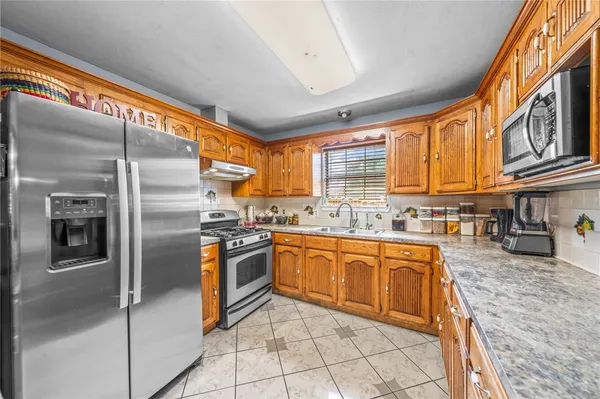 a kitchen with stainless steel appliances granite countertop a refrigerator and a sink