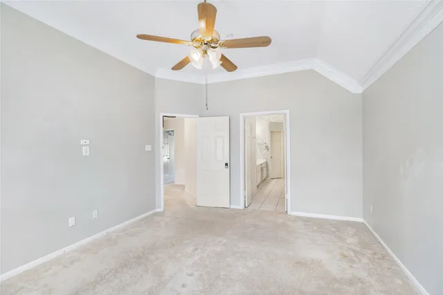 an empty room with ceiling fan and window
