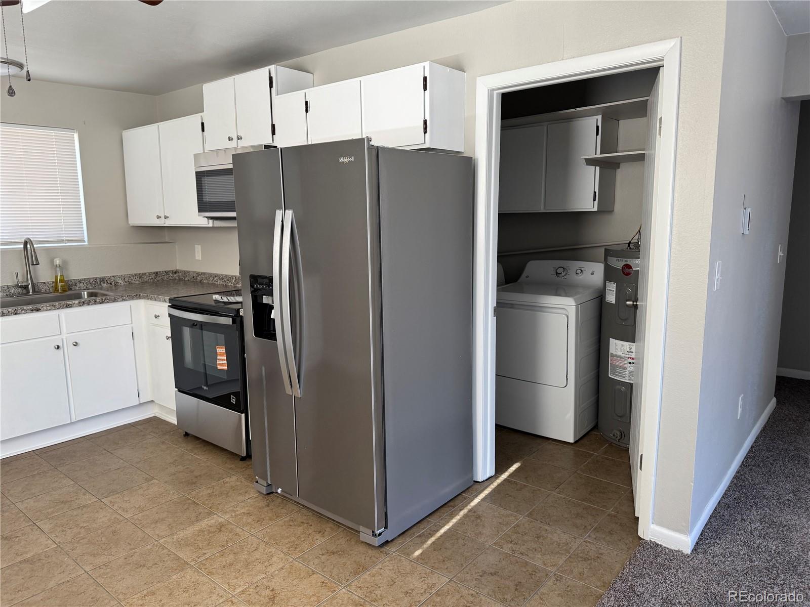 6021 Yarrow Street, Unit C23 Arvada, CO 80004 - Photo 1 of 6 a kitchen with stainless steel appliances a refrigerator stove and sink