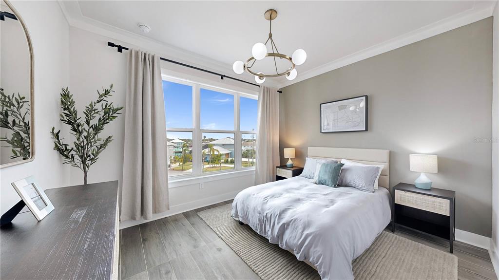 777 Gran Kaymen Way Apollo Beach, FL 33572 - Photo 19 of 30 a bedroom with a large bed and a chandelier