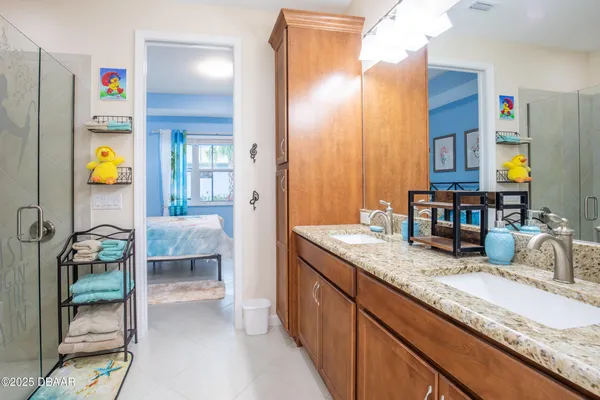 a en suite bathroom with a granite countertop sink and a mirror