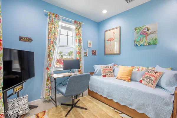 a living room with furniture a flat screen tv and a window