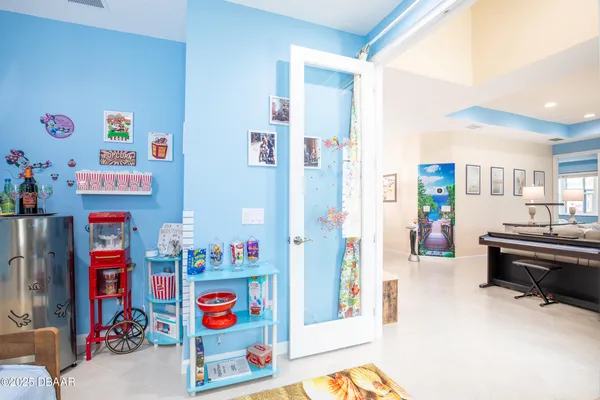 a living room with furniture and a refrigerator