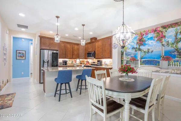 a kitchen with kitchen island a dining table and chairs