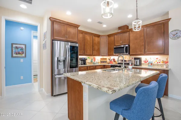 a kitchen with stainless steel appliances granite countertop a sink refrigerator and cabinets