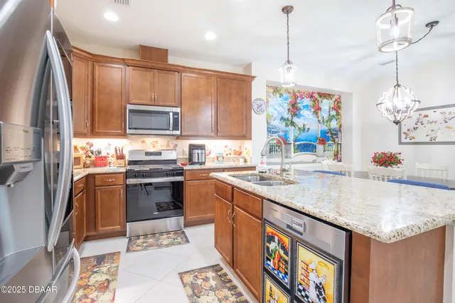 a kitchen with stainless steel appliances granite countertop a sink refrigerator and cabinets
