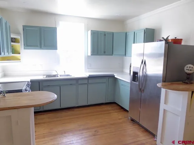 a kitchen with granite countertop a stove and a wooden floors