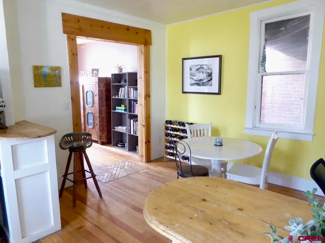 a kitchen with a table chairs and a wooden floor