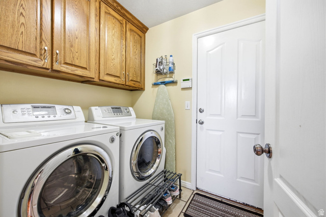 776 Flint Street Layton, UT 84041 - Photo 23 of 41 Dedicated laundry area featuring wood cabinetry, tiled flooring, and a white paneled door