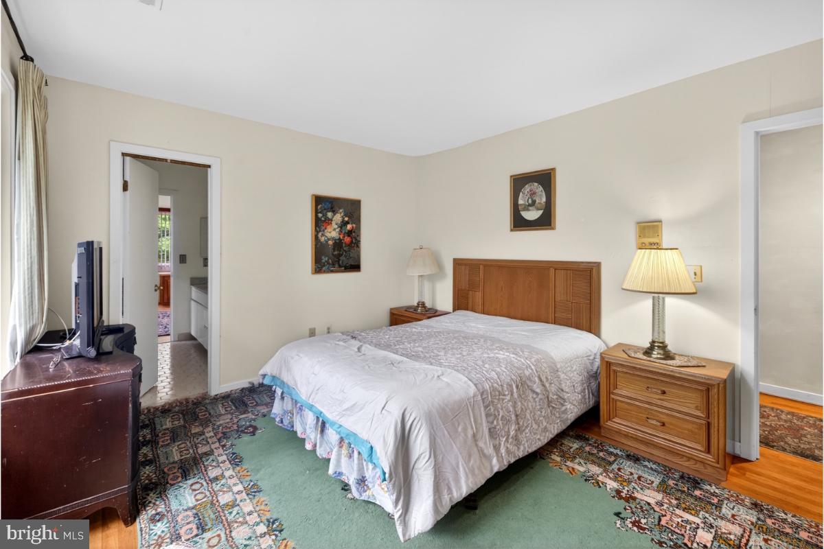 10320 Glen Road Potomac, MD 20854 - Photo 29 of 75 a bedroom with a bed and a lamp on table