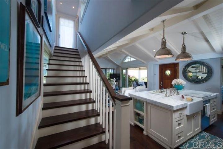 111 10th Street Del Mar, CA 92014 - Photo 11 of 23 a kitchen with a stove a clock and a dining table with chairs
