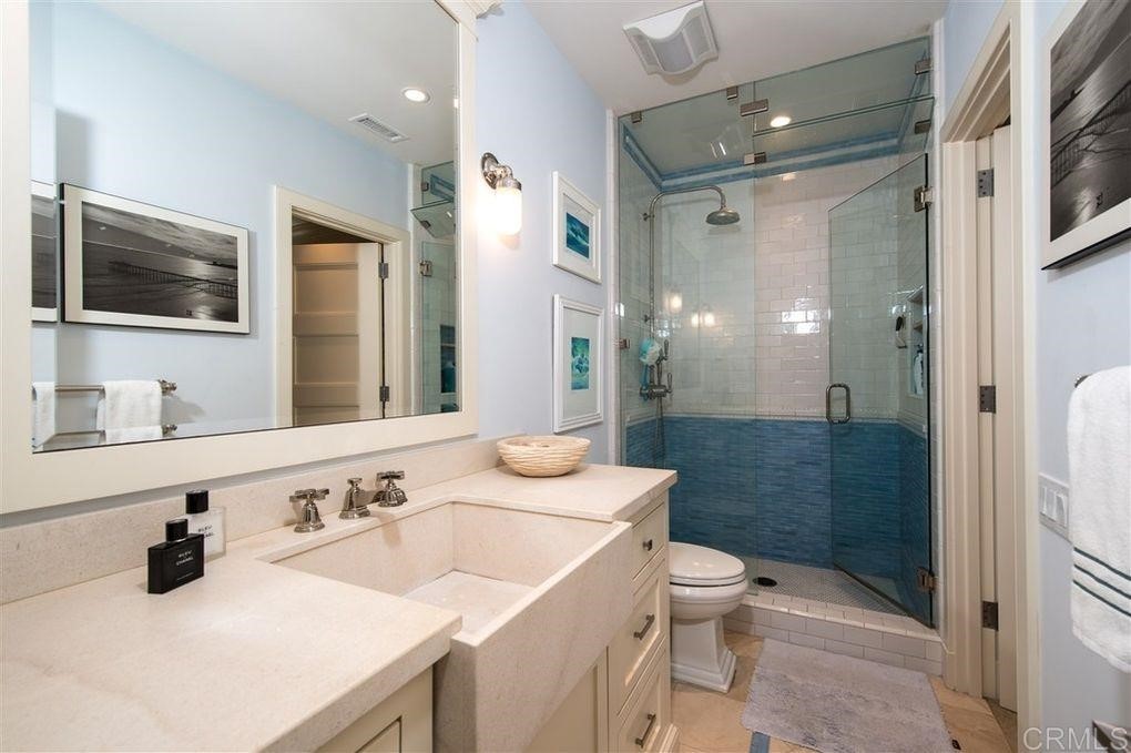 111 10th Street Del Mar, CA 92014 - Photo 16 of 23 a bathroom with a sink a toilet a mirror and shower