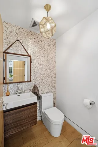 a bathroom with a toilet a sink and mirror