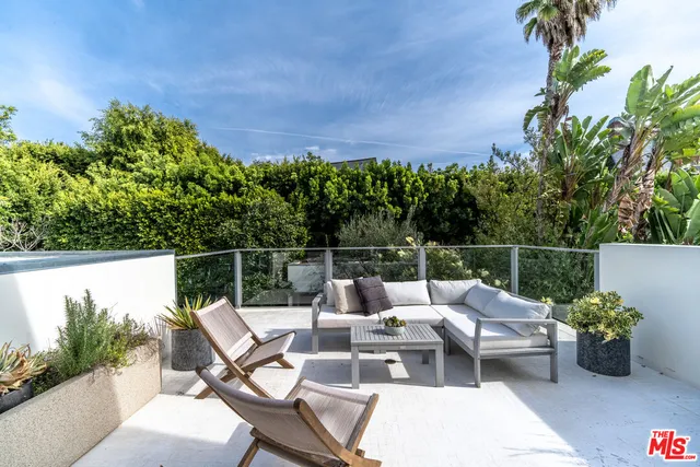 a view of a balcony with chairs and a potted plant