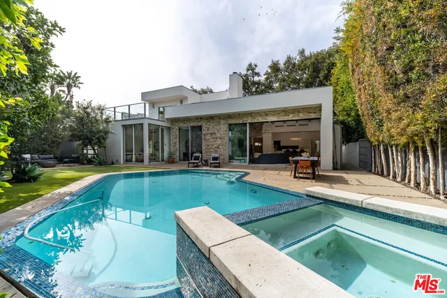 a view of a house with swimming pool and sitting area