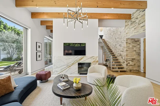 a living room with furniture fireplace and a large window