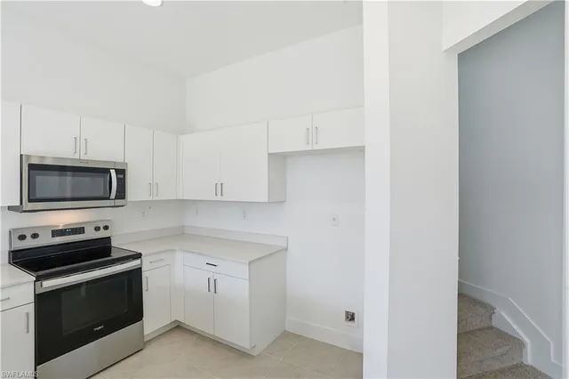 a kitchen with a sink a refrigerator and cabinets