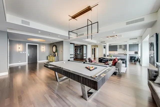 a dining hall view with a dining table wooden floor and a chandelier
