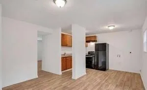 a view of a kitchen with refrigerator and wooden floor