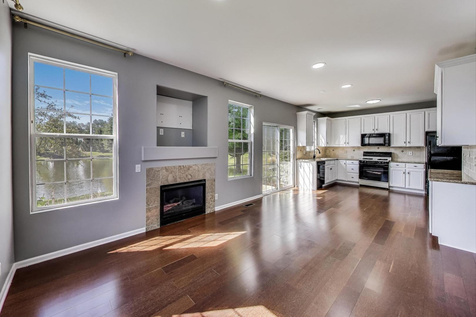 383 Cascade Lane Oswego, IL 60543 - Photo 12 of 35 a living room with stainless steel appliances furniture a fireplace and wooden floor
